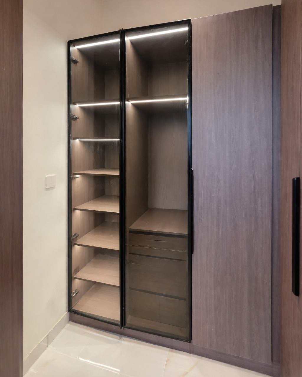 Custom fitted wardrobe with glass doors and lighting